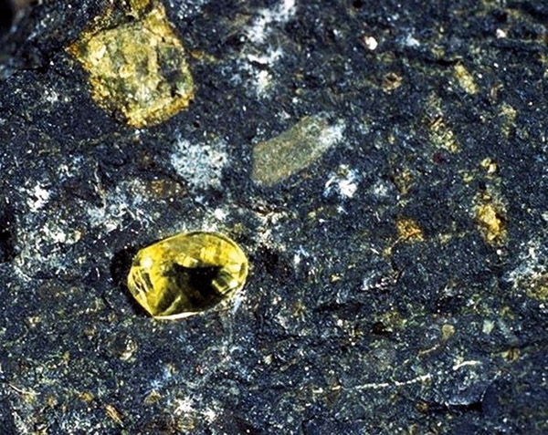 Приклад кимберлитовой породи з алмазами (жовті) і гранатами піропами (дрібні червоні)