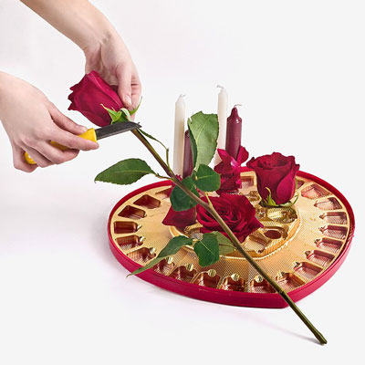 Ножем коротко подрежьте троянди і покладіть їх в осередки з водою ближче до центру композиції